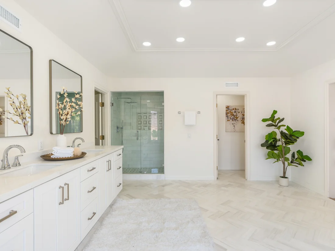 Primary bathroom remodel — white shaker vanity, walk-in marble shower, and herringbone floors in Coto de Caza