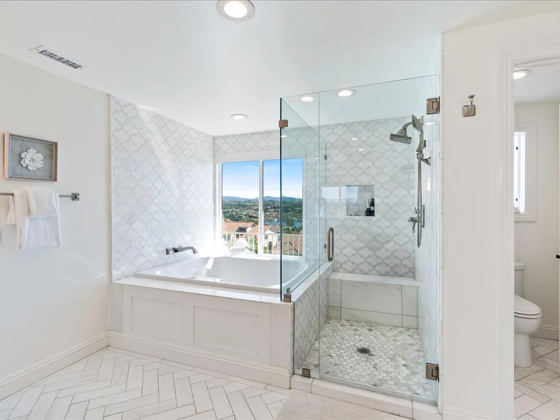 View-forward primary bath remodel in Mission Viejo with arabesque marble tile and lake views