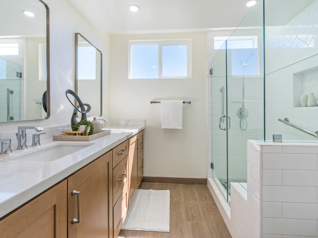 Warm transitional family bath remodel in Mission Viejo with oak-grain vanity and white quartz counters