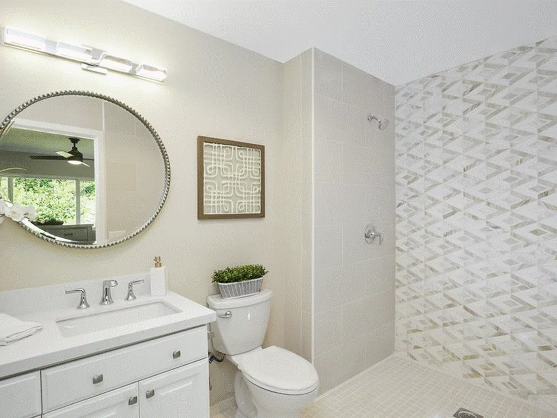 Mission Viejo bathroom remodel with statement waterjet marble shower wall and oval beaded mirror